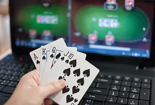 Top Online Blackjack Games - Picture of Hand Holding Cards in Front of Laptop